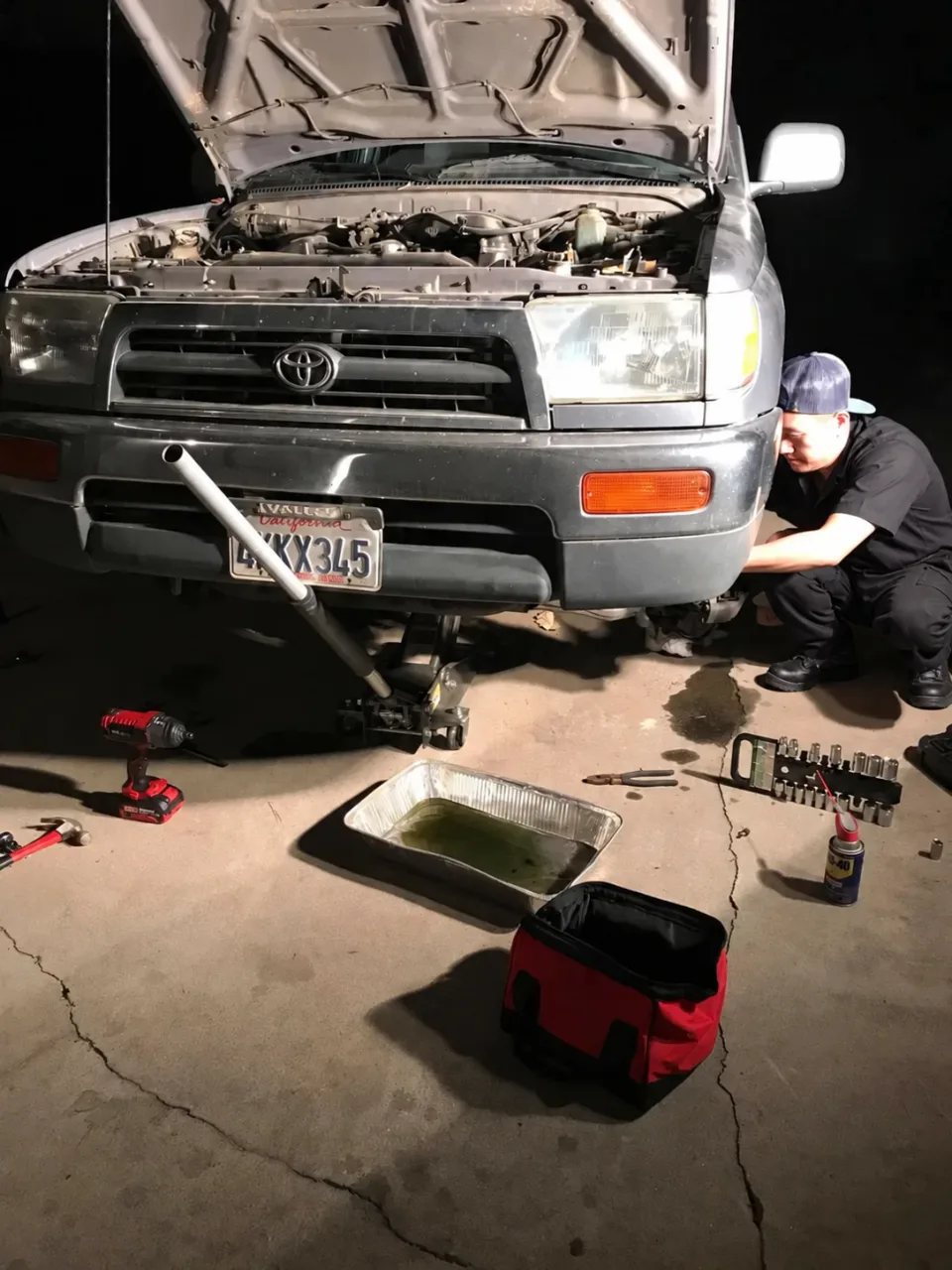 Monty performing a mobile oil change on a Toyota 4Runner in a customer's driveway